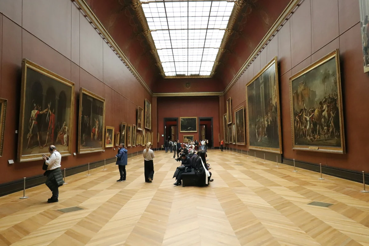Visitors looking at paintings in the Grand Gallery of the Louvre